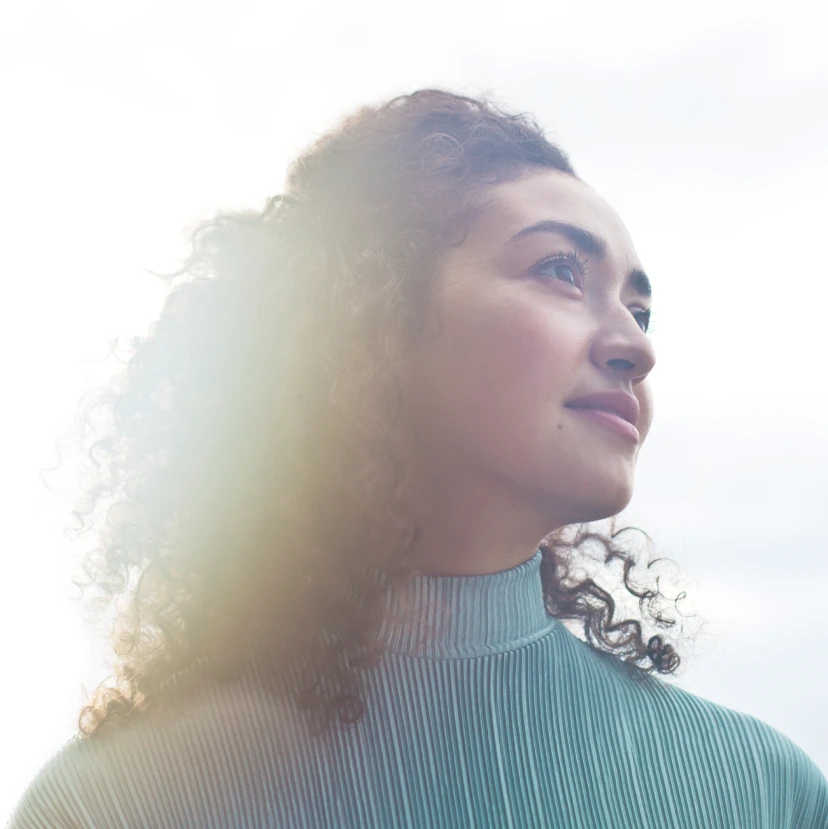 A woman in a turtleneck looks ahead