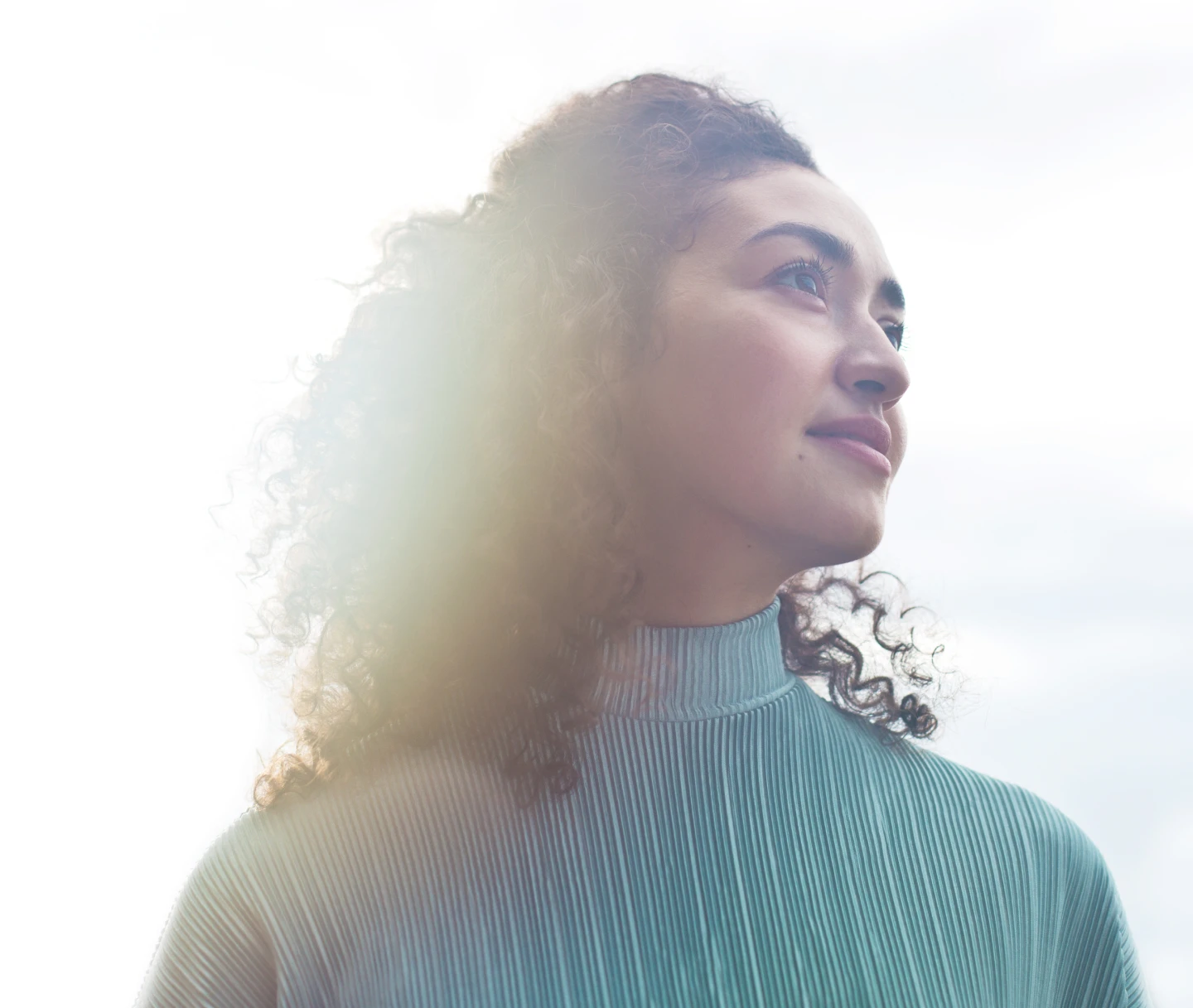 A woman in a turtleneck looks ahead
