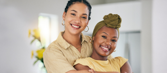 Two women embracing and smiling indoors