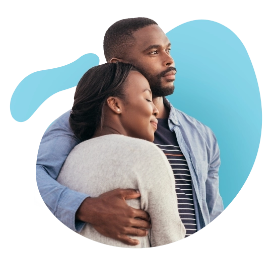 A couple embraces and laughs against a blue background