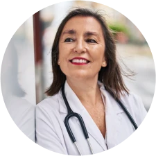 A fertility specialist crosses her arms and smiles against a gray background